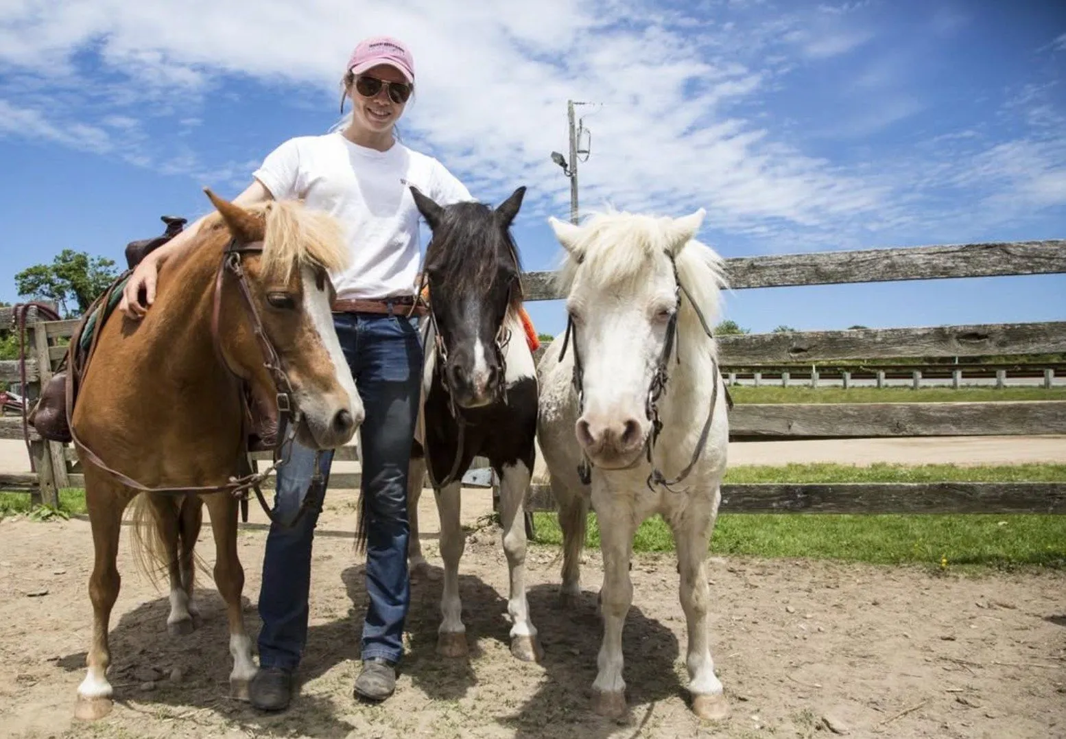 A wrangler leading three ponies